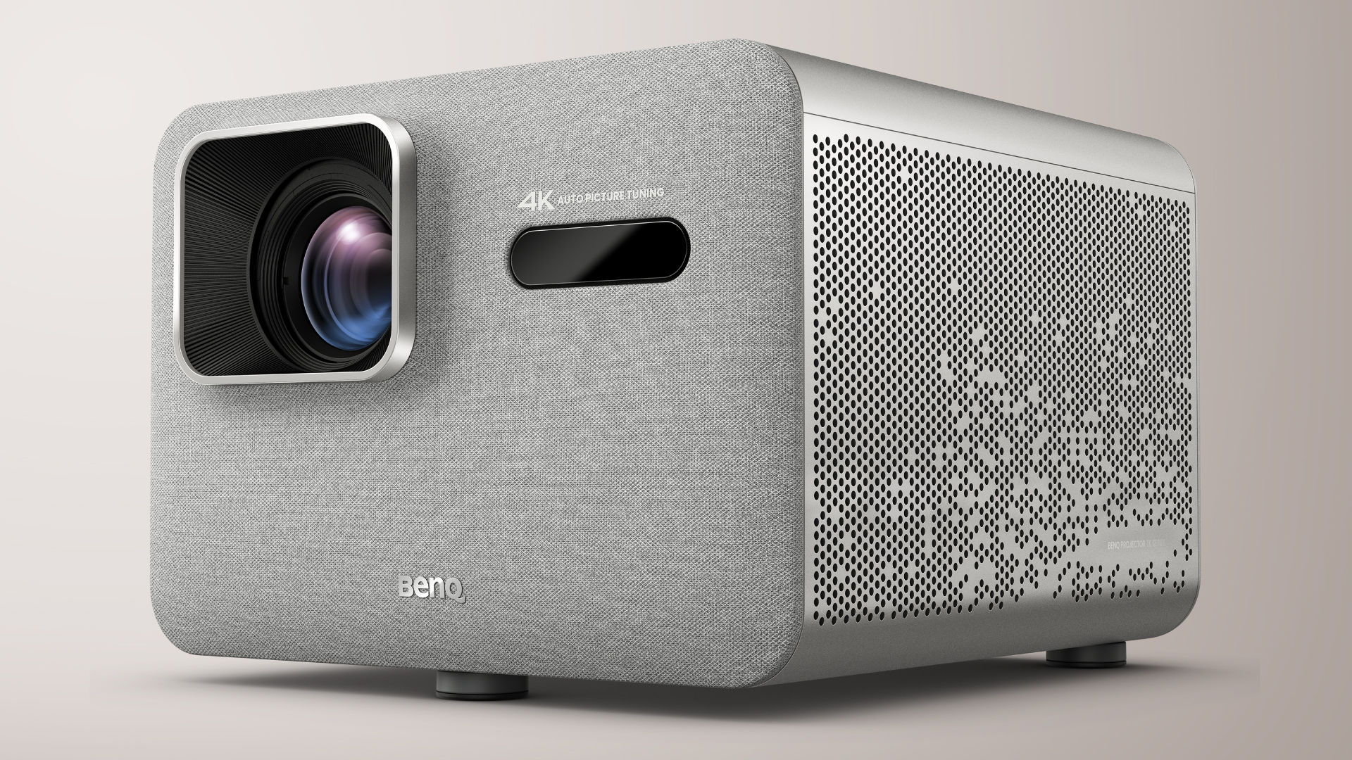 BenQ TK705i front three-quarter view: light grey fabric-covered front with a square lens at the upper left, a dark sensor window and a perforated metal side panel