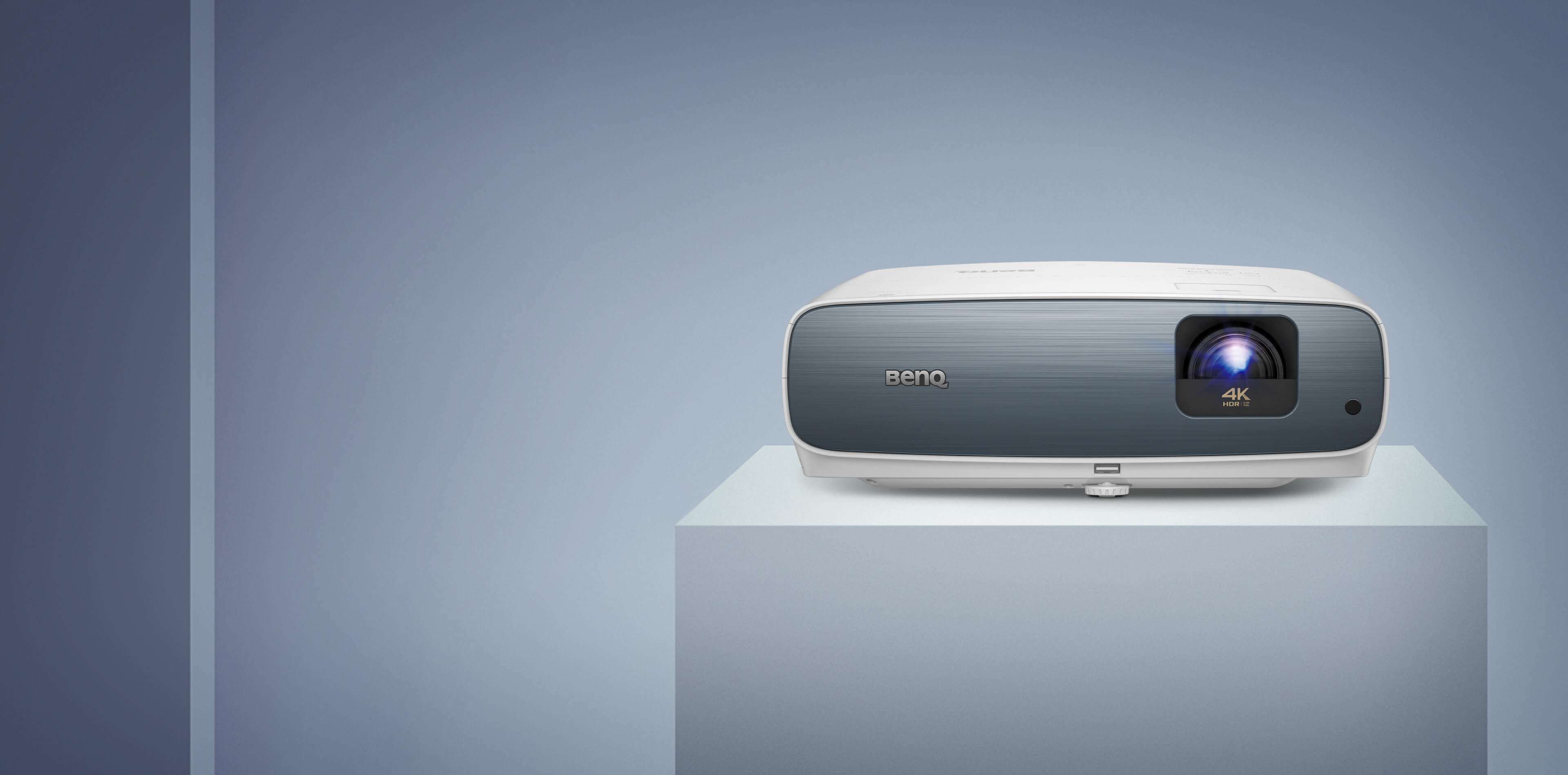 BenQ TK850 projector on a pale plinth, front view with blue-grey fascia and 4K HDR lens badge