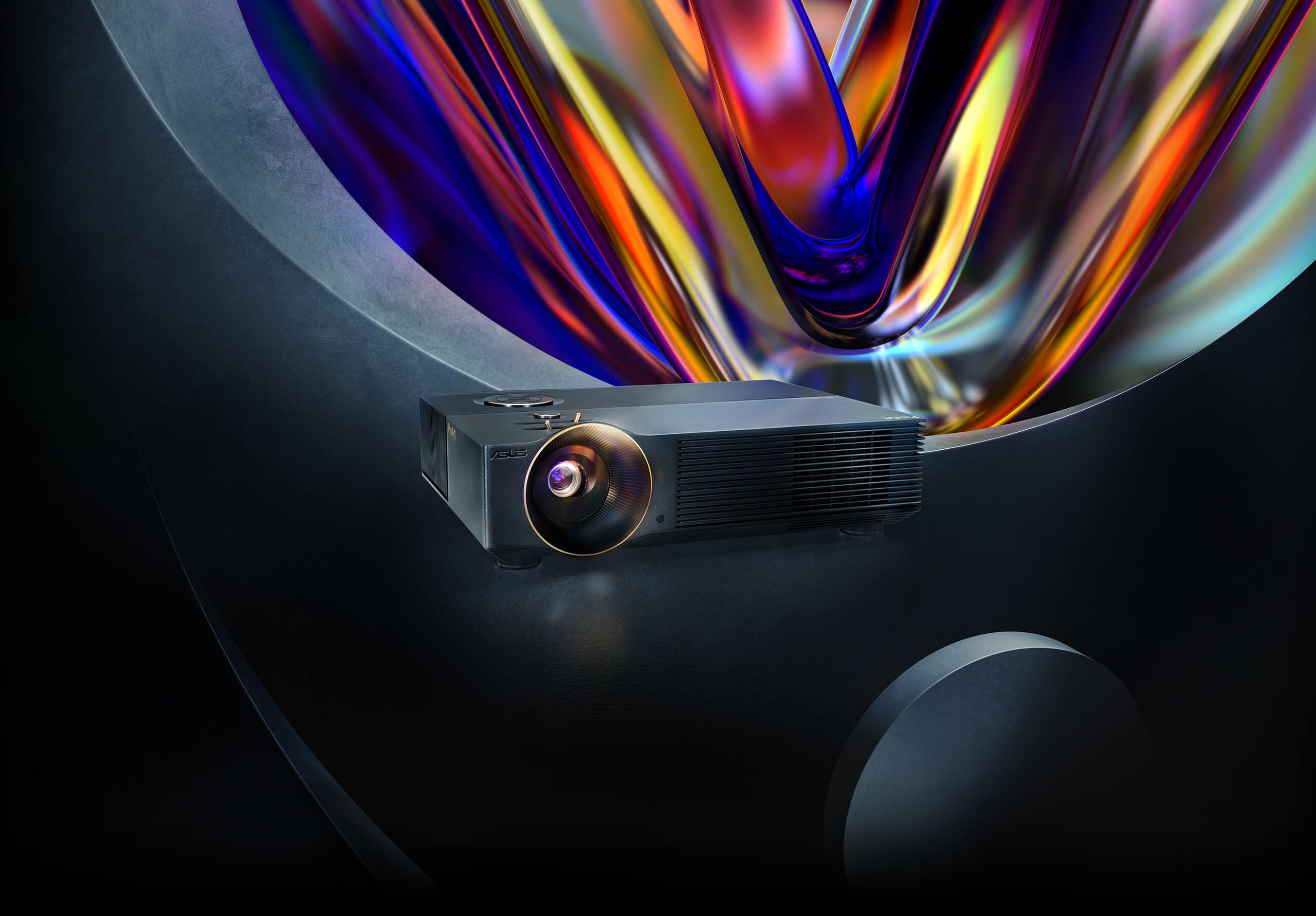 ASUS ProArt Projector A1 front three-quarter view, black chassis with a gold-ringed lens, on a dark stage