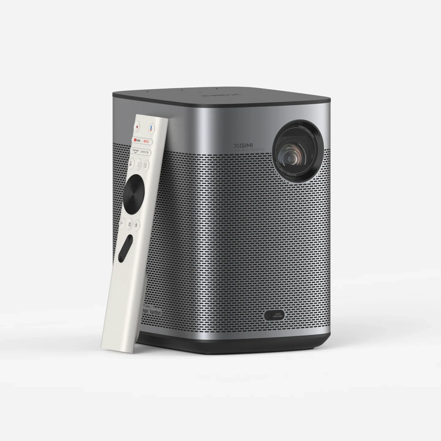 XGIMI Halo+ (New) portable projector, front three-quarter view, silver mesh body with the lens at upper right and the white Bluetooth remote leaning against it