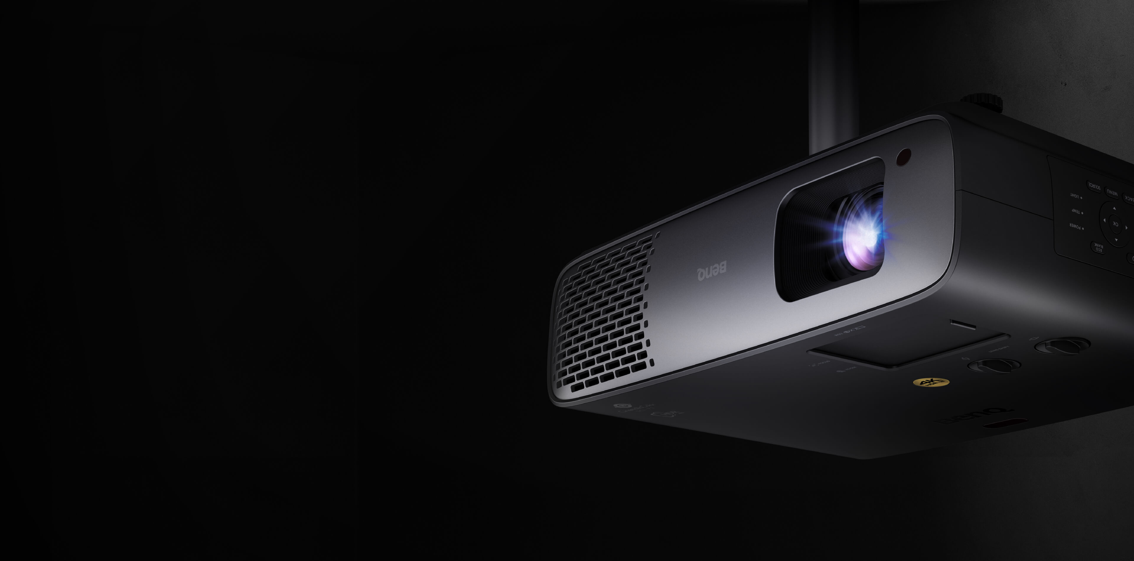 BenQ HT4550i ceiling-mounted, front three-quarter view with a blue-white glow from the lens against a dark background